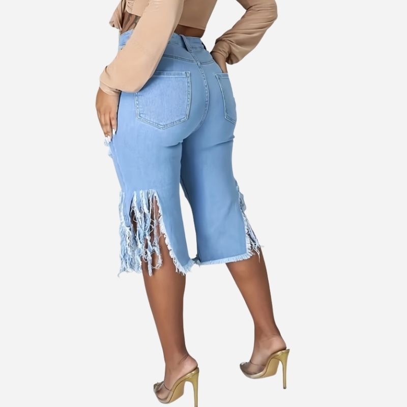 Women's high waisted ripped denim capri shorts raw hem chain distressed in blue, side view